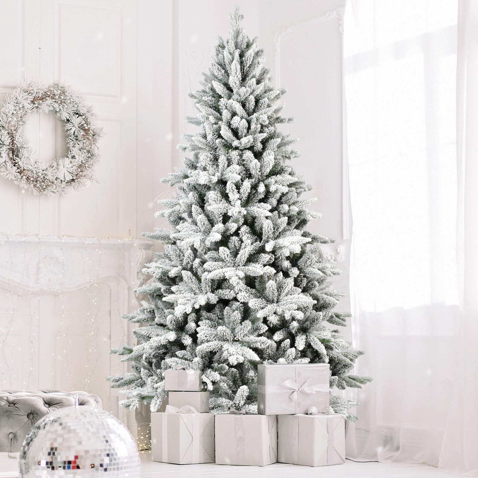 7ft flocked Christmas tree with 1514 tips, snowy branches beside wrapped gifts in a bright room on Tampa Home & Garden Store
