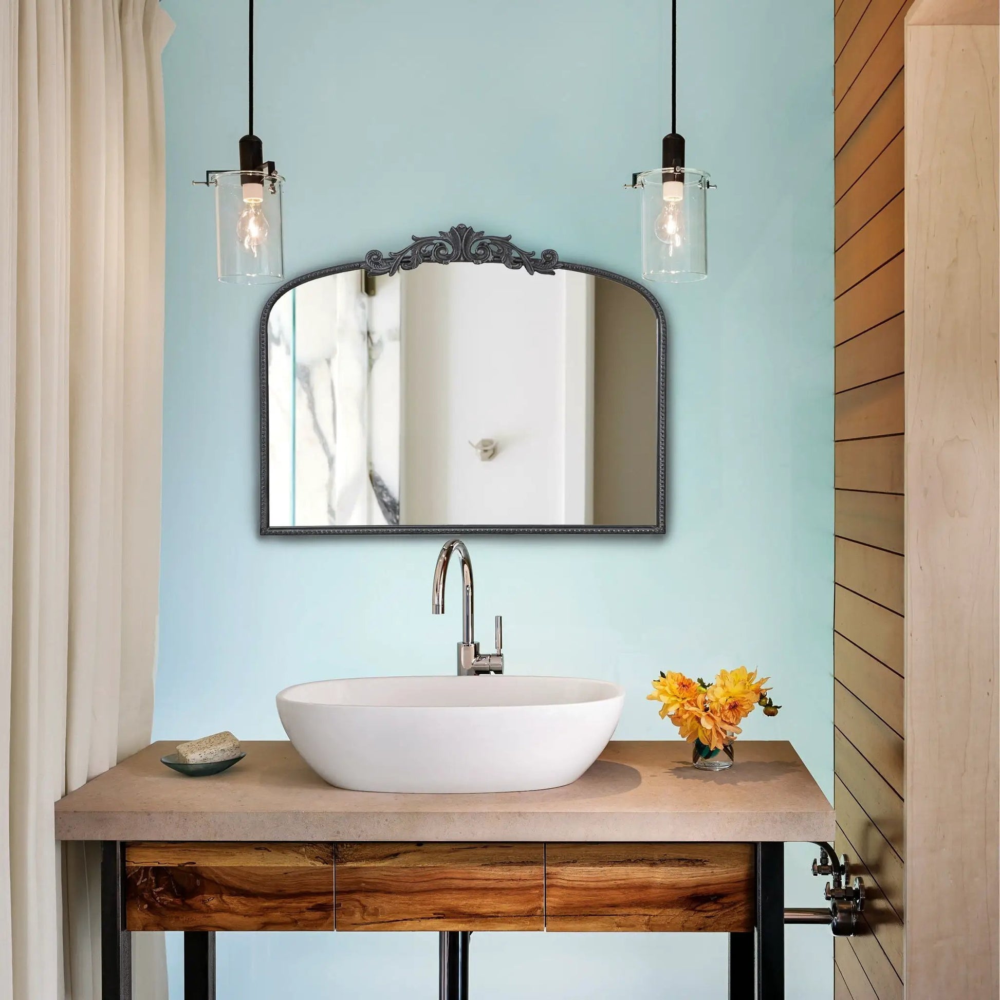 Arch Mirror with baroque-inspired black frame over a white vessel sink in a blue bathroom on Tampa Home & Garden Store
