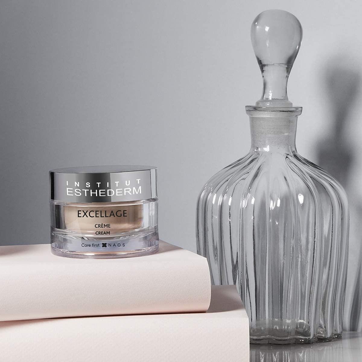 Excellage face cream jar from Institut Esthederm with beige cream beside ribbed glass decanter on Tampa Home & Garden Store
