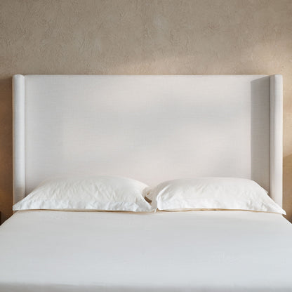 Hosford minimalist upholstered wingback bed in light beige fabric with white bedding on Tampa Home & Garden Store