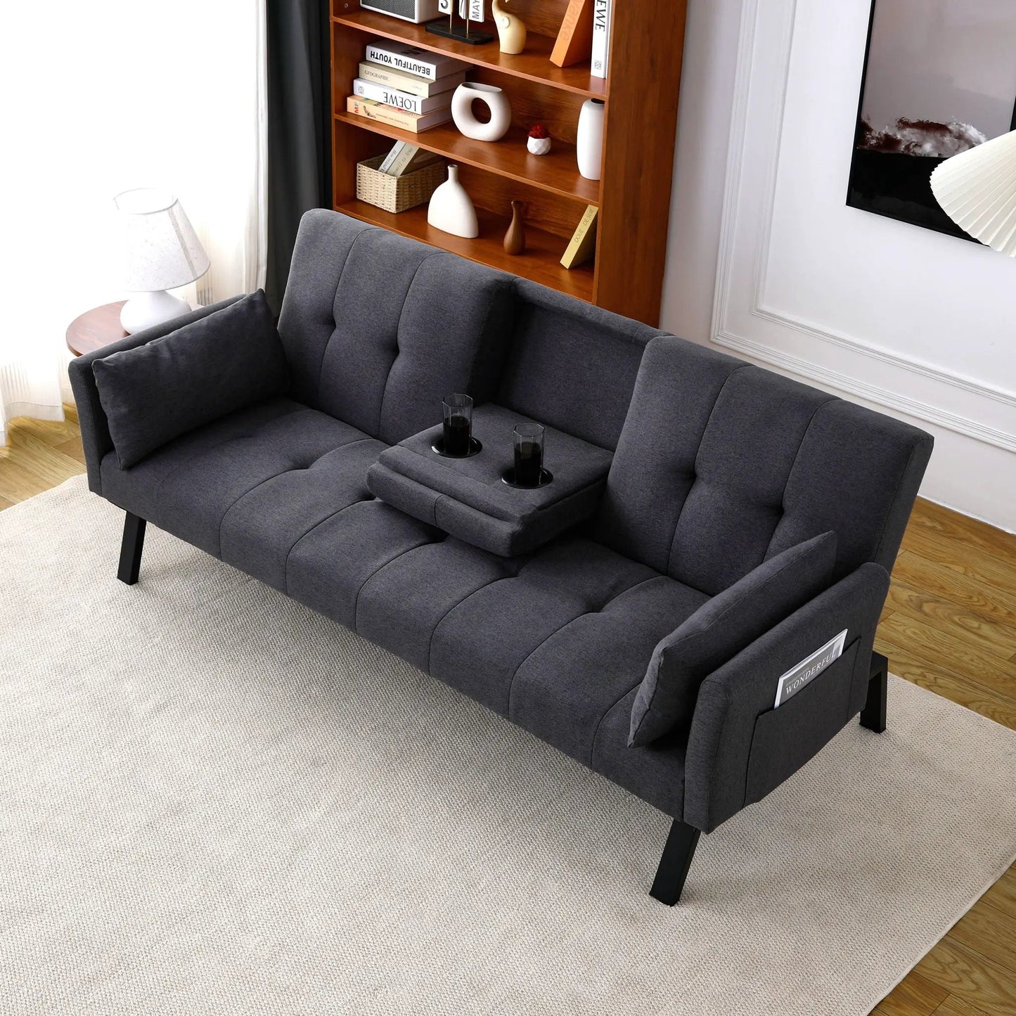 Futon sofa bed in dark gray fabric with foldable design and two cup holders on Tampa Home & Garden Store