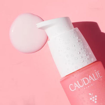 Caudalie Vinosource Hydra SOS Hydrating Serum bottle with white pump, pink backdrop on Tampa Home & Garden Store