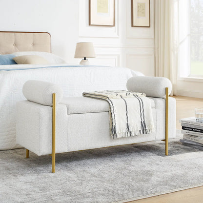 Elegant upholstered storage bench with cylindrical arms and gold iron legs at the foot of a bed on Tampa Home & Garden Store