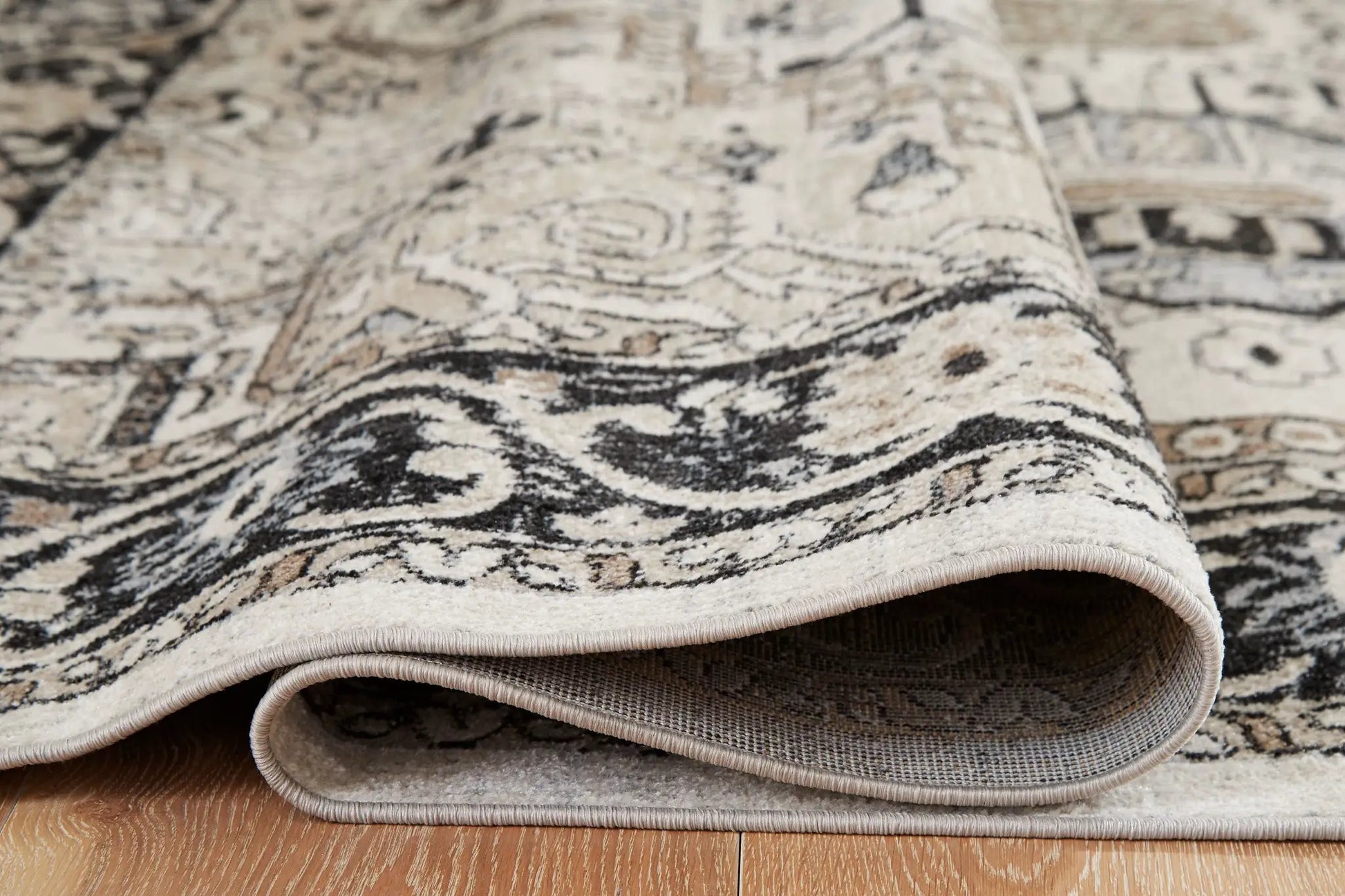 Gregmoore area rug by Unique Piece Furniture, washable beige and black pattern with rolled edges on Tampa Home & Garden Store