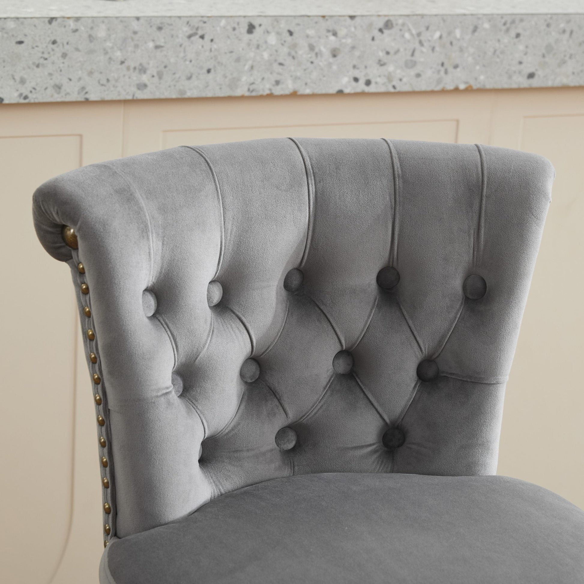 Gray velvet tufted chair with buttoned back and brass nailhead trim on Tampa Home & Garden Store