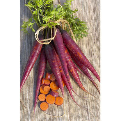 Cosmic Purple Carrot bunch with green tops and orange carrot cross-sections on wooden surface on Tampa Home & Garden Store