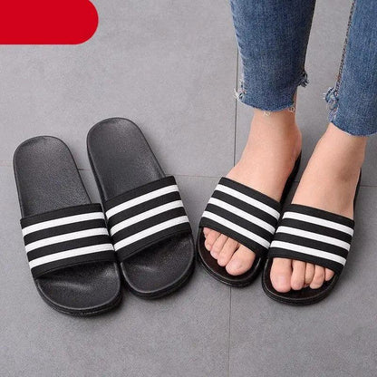 Two pairs of black and white striped slide sandals with open toe for casual summer wear on Tampa Home & Garden Store