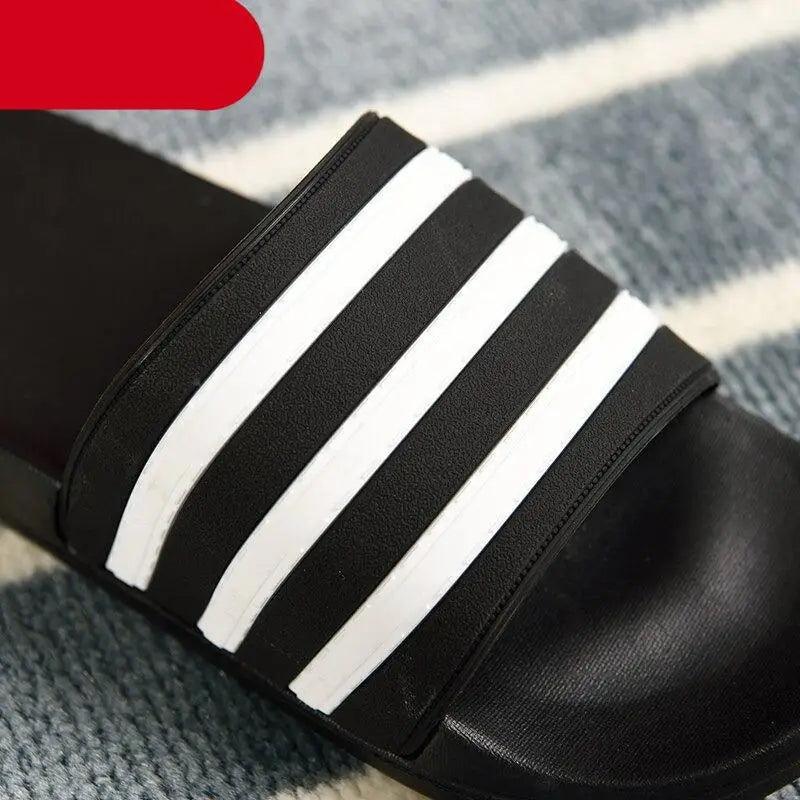 Casual summer slide sandal with black base and white striped wide strap for outdoor wear on Tampa Home & Garden Store
