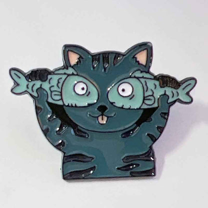 Cat enamel pin featuring teal body, goofy wide-eyed expression, fish accents on Tampa Home & Garden Store