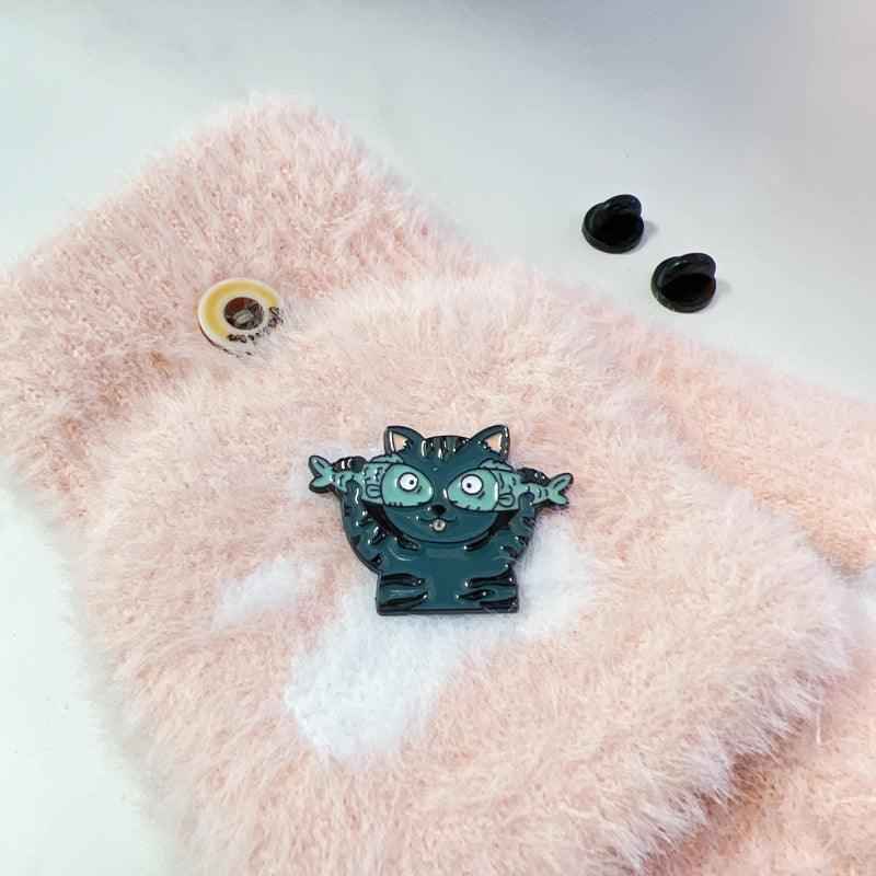 Cat with Fish enamel pin by Shaketea, teal cat with wide eyes and outstretched paws on Tampa Home & Garden Store