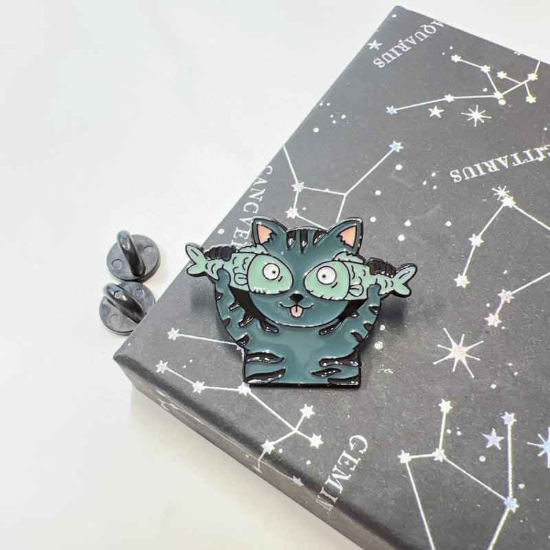 Cat enamel pin by Shaketea, teal goofy cat with wide eyes on constellation card on Tampa Home & Garden Store