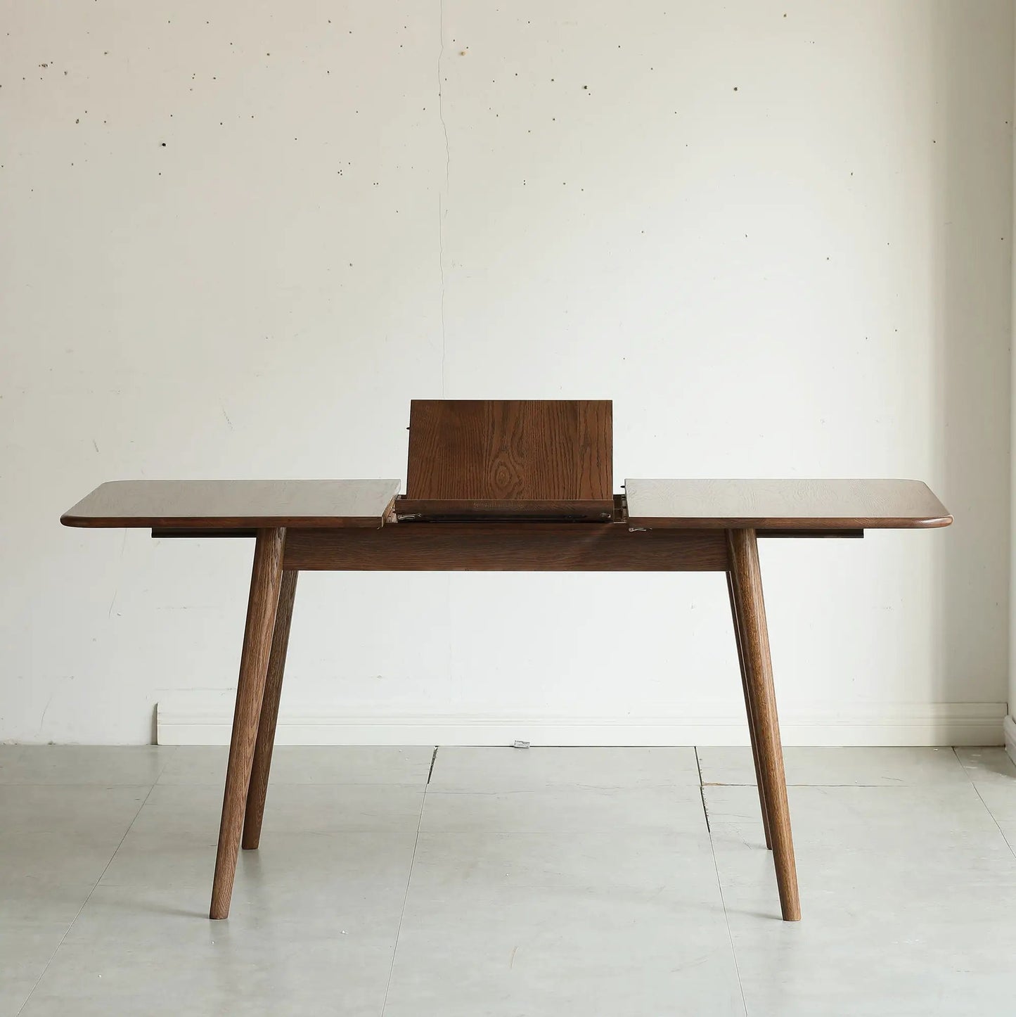 Dining table with rounded corners and diagonal legs in dark wood with telescoping leaves for 6–8 on Tampa Home & Garden Store