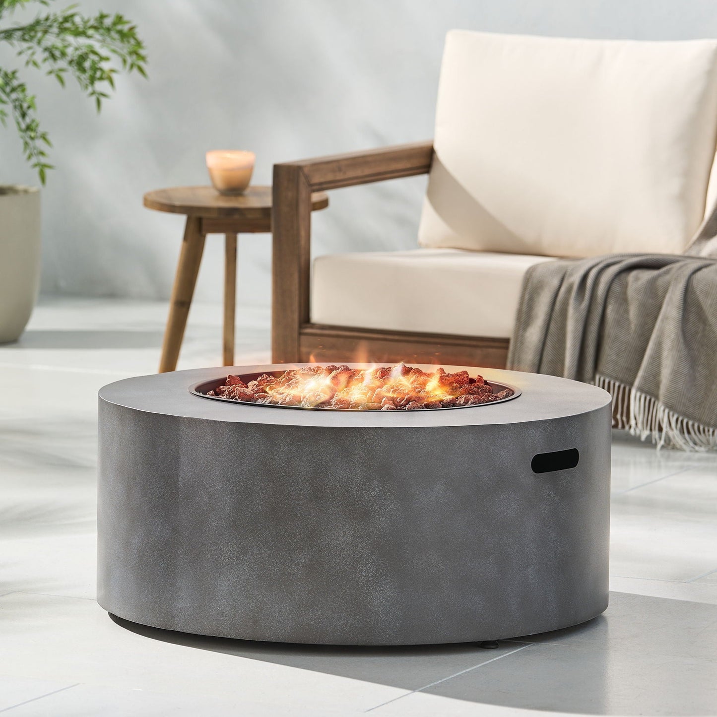 Round iron fire pit with lava rocks and glowing embers, gray metal finish 40,000 BTU on Tampa Home & Garden Store