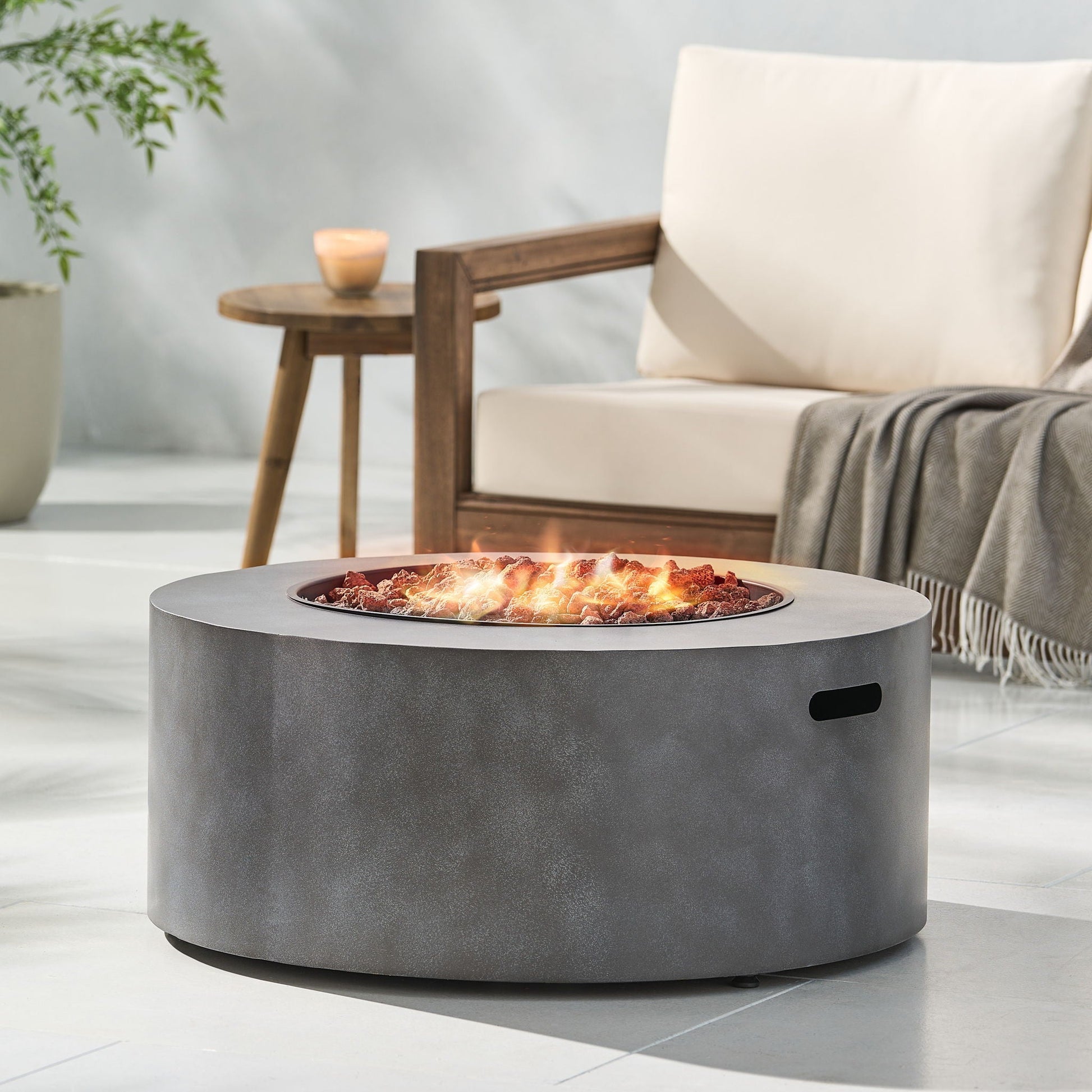Round iron fire pit with lava rocks and glowing embers, gray metal finish 40,000 BTU on Tampa Home & Garden Store