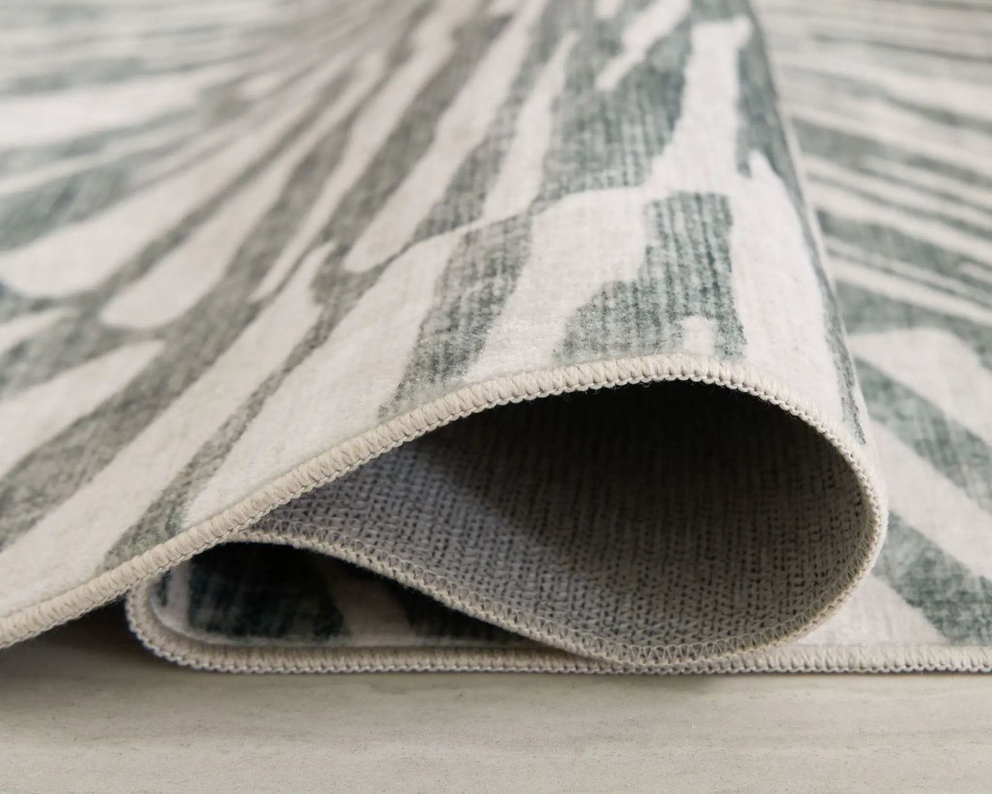 Verland washable rug in gray zebra pattern by Unique Piece Furniture, rolled-edge close-up on Tampa Home & Garden Store