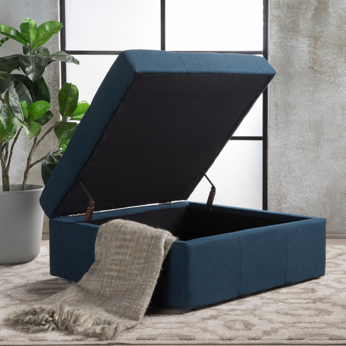 Navy blue flip-top ottoman with tufted waffle stitch and rolling casters, open storage on Tampa Home & Garden Store