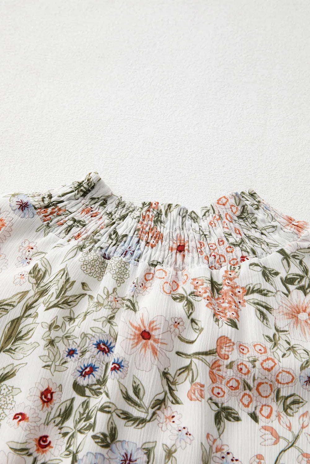 Floral printed smocked-neck long sleeve mini dress Stevvex with green leaves and peach blooms on Tampa Home & Garden Store