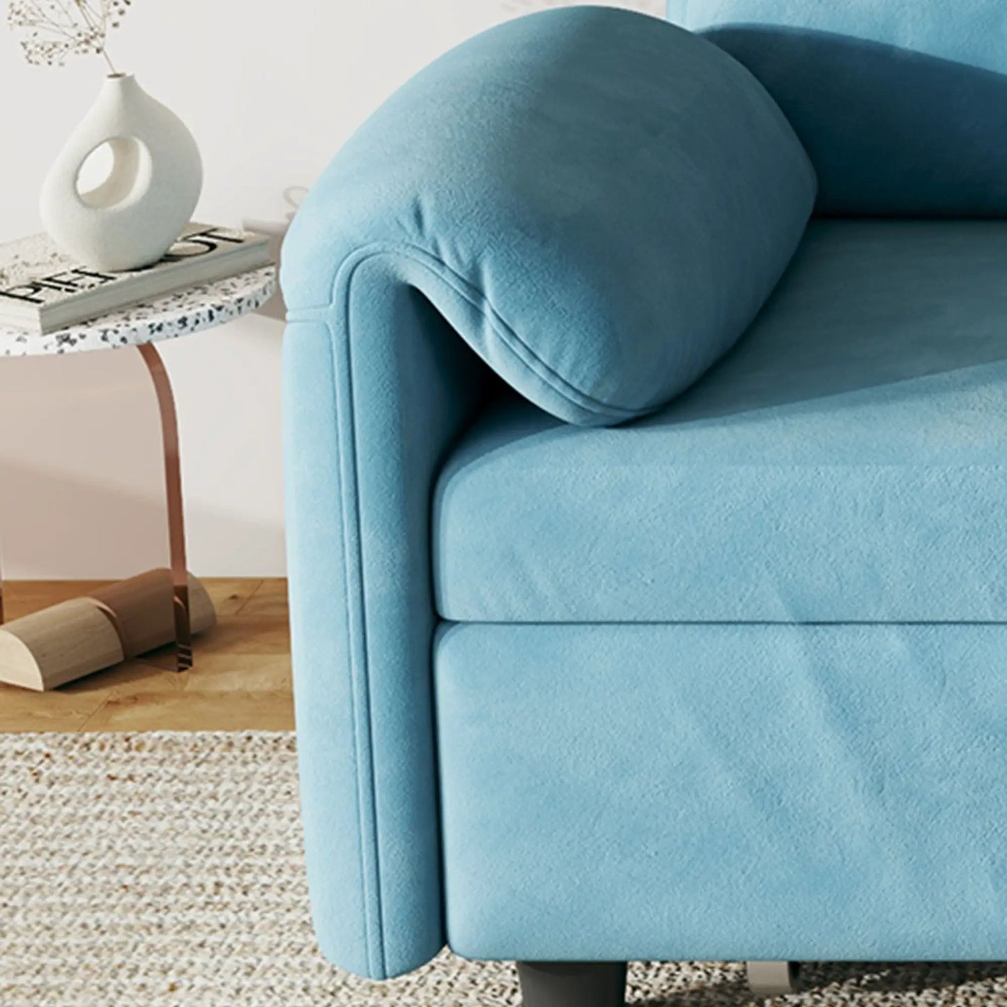 Sleeper sofa arm in blue textured fabric with a white vase on a speckled side table on Tampa Home & Garden Store