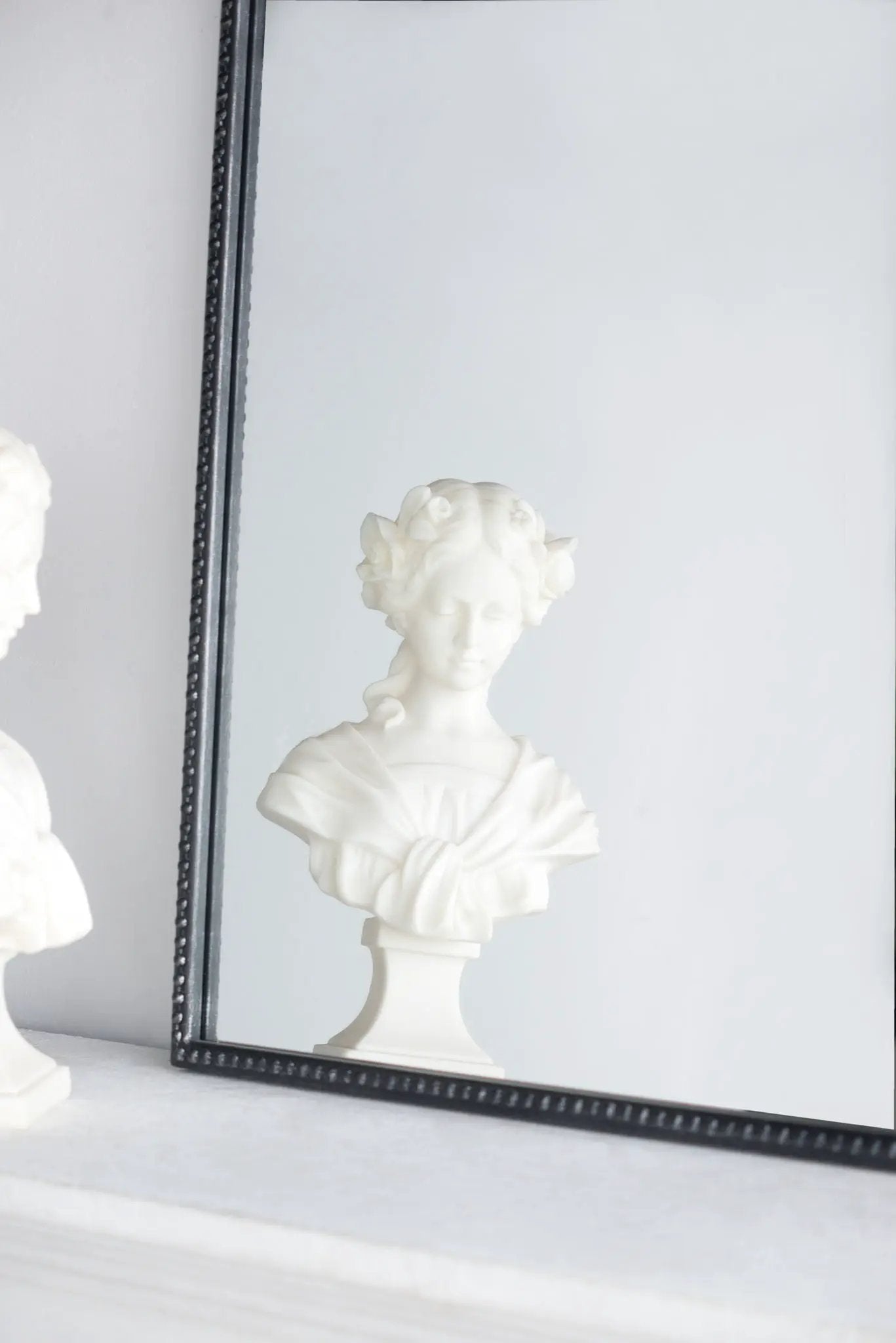Arch Mirror with black beaded frame, Baroque-inspired wall decor reflecting a white bust on a shelf on Tampa Home & Garden Store