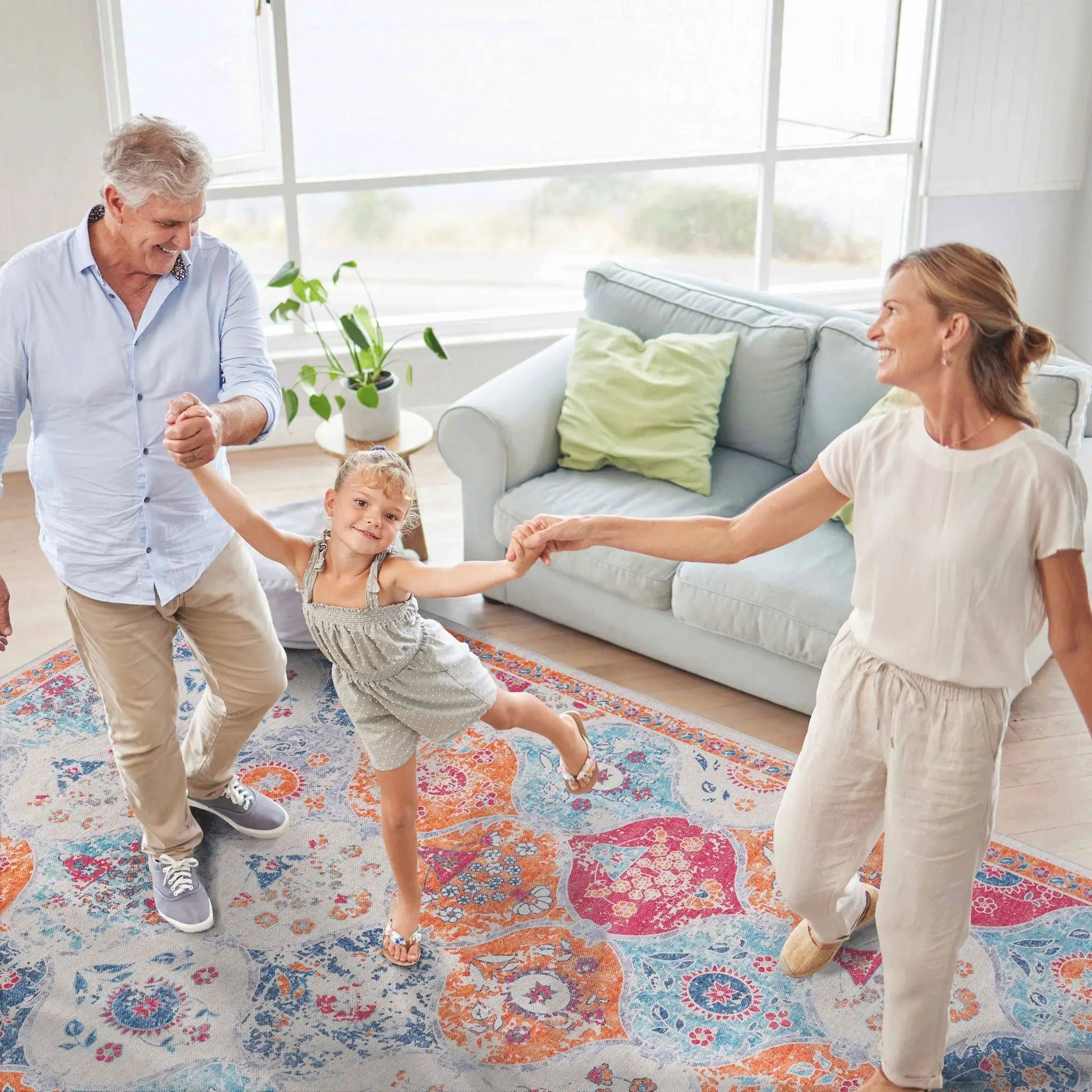 Maval area rug by Unique Piece Furniture with blue orange pink pattern in a living room on Tampa Home & Garden Store