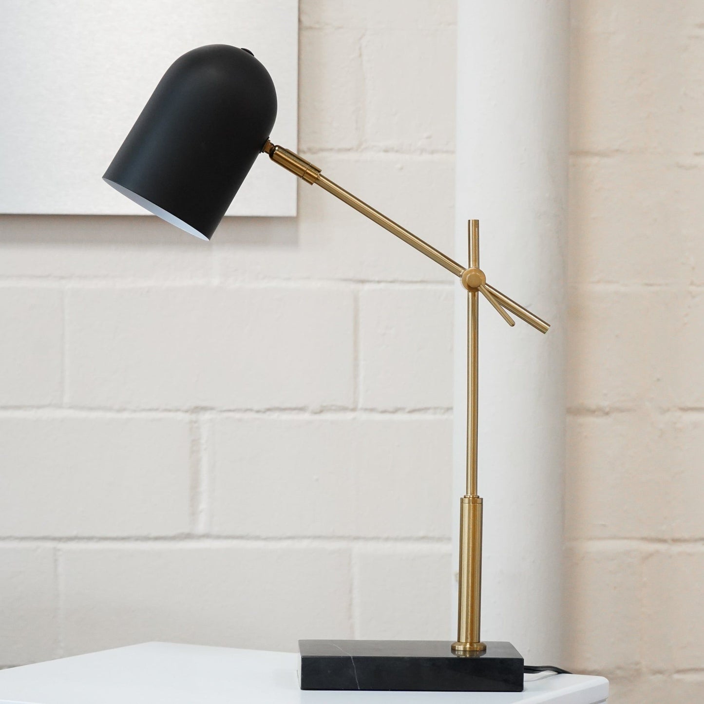 Lumora table lamp with black shade, brass adjustable arm, black square base on Tampa Home & Garden Store