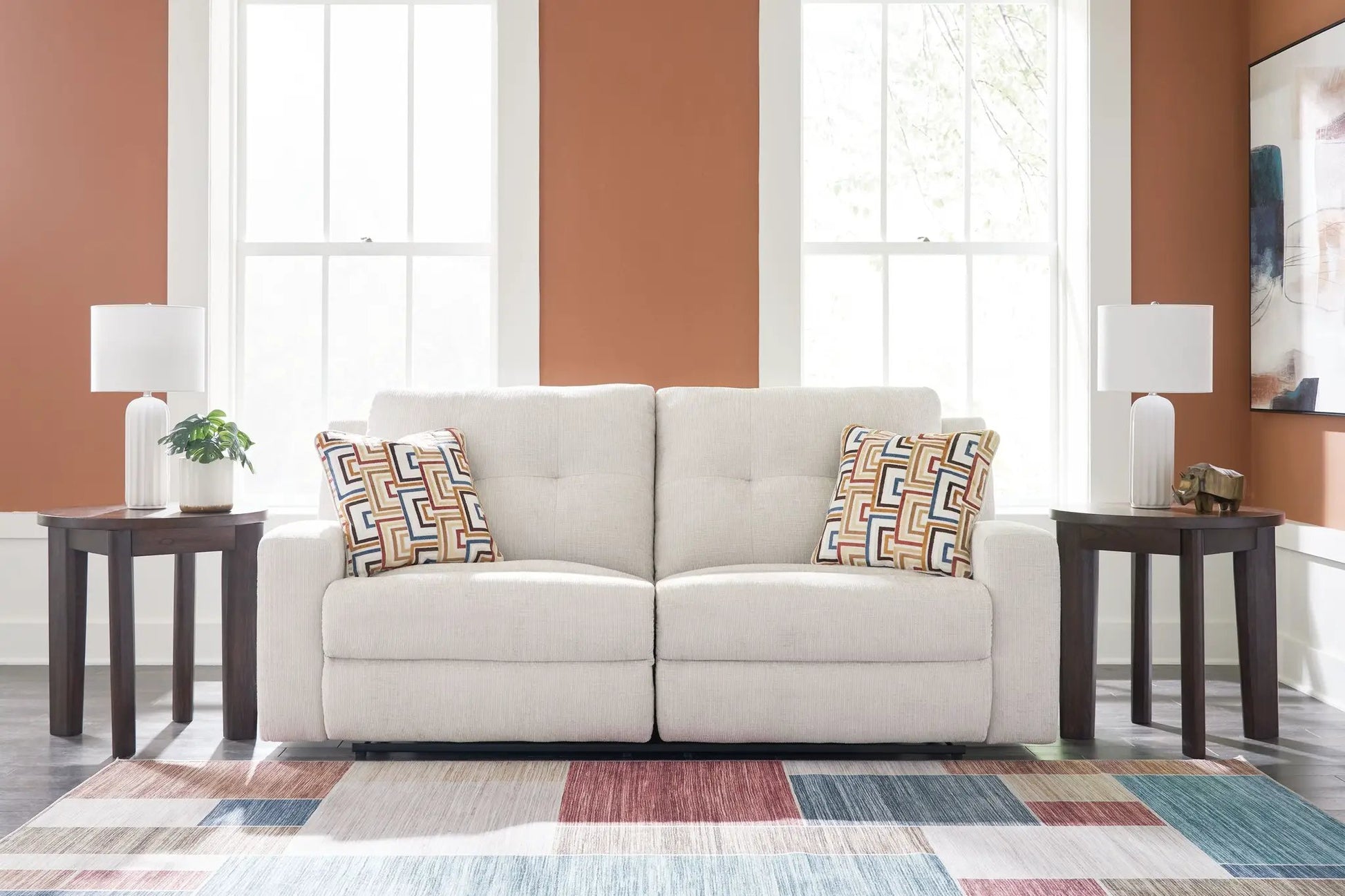 Danum 2-seat reclining sofa in light beige fabric with patterned cushions on Tampa Home & Garden Store