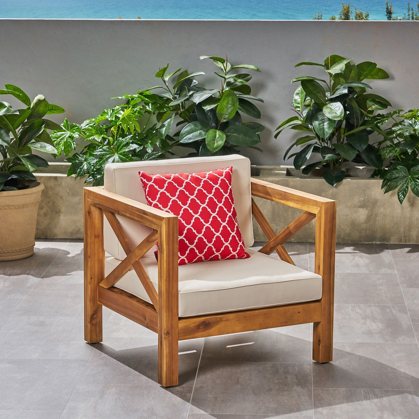 Brava mid-century outdoor arm chair with water resistant cushions and red geometric pillow on Tampa Home & Garden Store