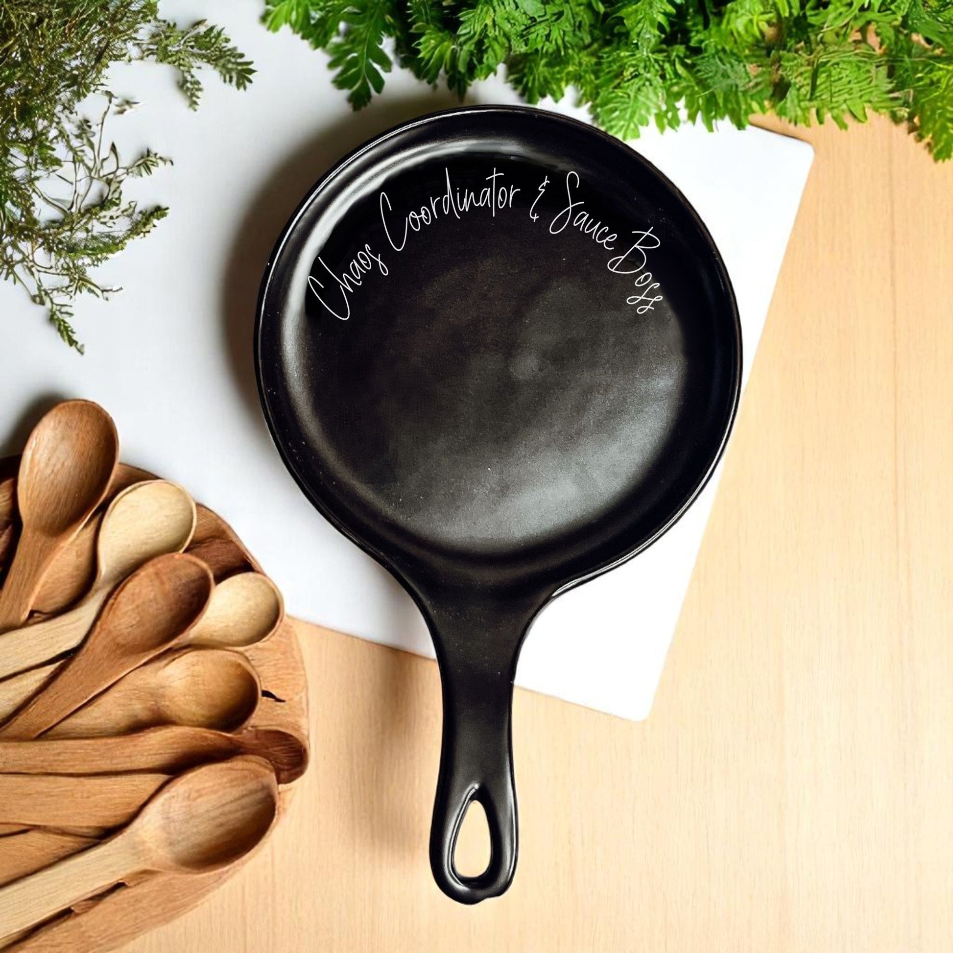 Chaos & Sauce Boss spoon rest by Gia Roma in black skillet style on wood surface with greenery on Tampa Home & Garden Store