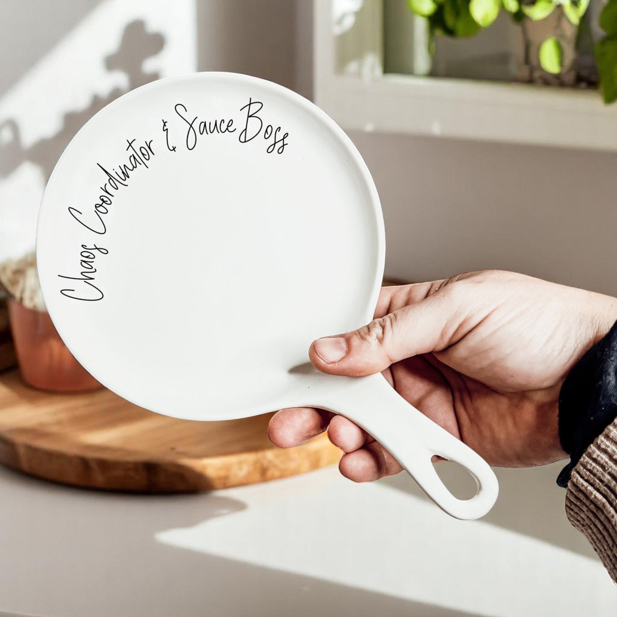 Spoon rest Chaos & Sauce Boss by Gia Roma, white ceramic with black cursive edge text on rim on Tampa Home & Garden Store