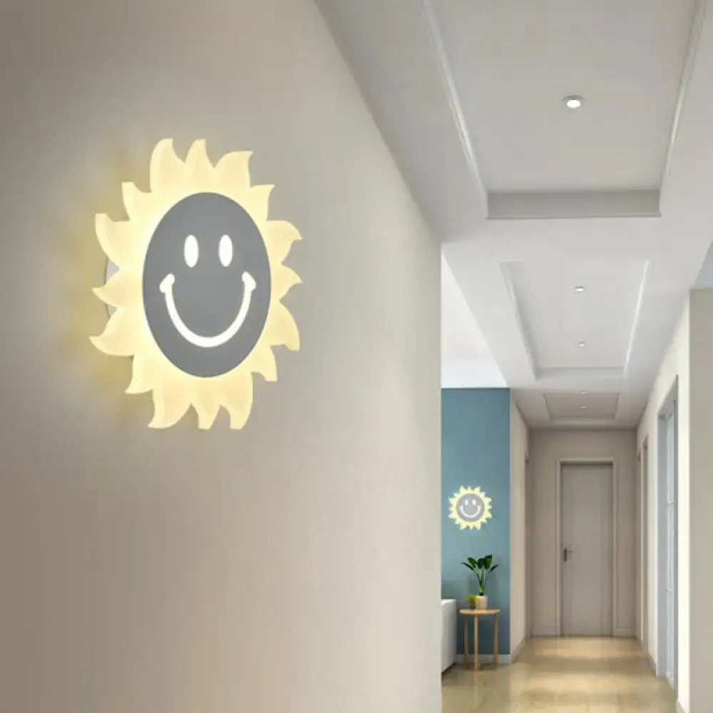 White Sun Wall Sconce by Decorbites, sunburst cream rays with gray smiley center, warm glow on Tampa Home & Garden Store