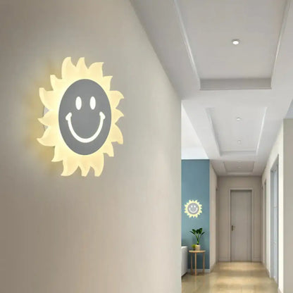 White Sun Wall Sconce by Decorbites, sunburst cream rays with gray smiley center, warm glow on Tampa Home & Garden Store