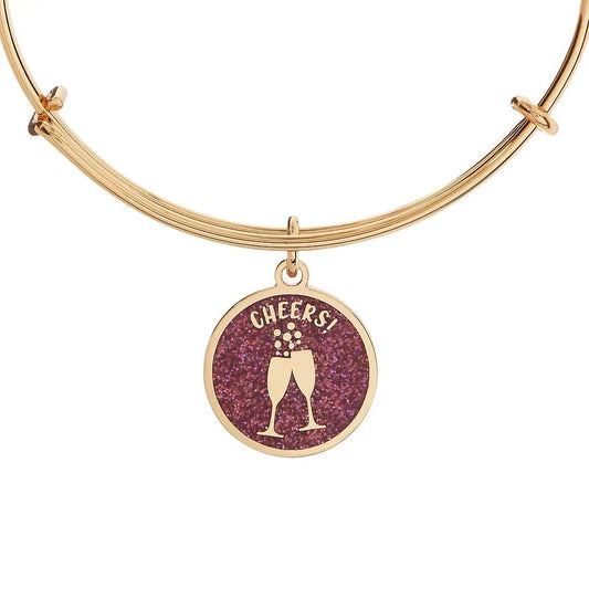 Gold-tone bangle with glitter purple charm of two champagne glasses and CHEERS text by ALEX AND ANI on Tampa Home & Garden Store