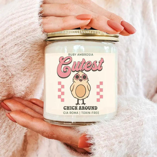 Candle Ruby Ambrosia Gia Roma in a glass jar with pink label featuring a chick illustration on Tampa Home & Garden Store
