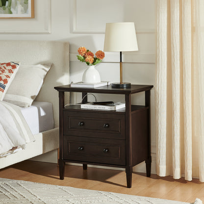 Wooden bedside nightstand with open cubby and two drawers, topped with white lamp and flowers on Tampa Home & Garden Store
