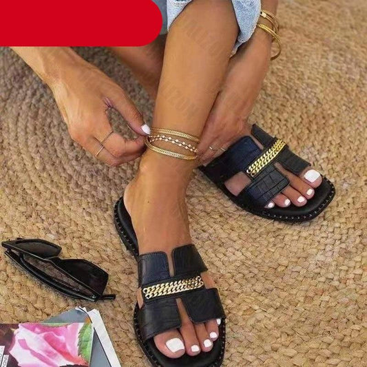 Stevvex black double-chain flat sandals with gold straps worn by a model on a woven rug on Tampa Home & Garden Store
