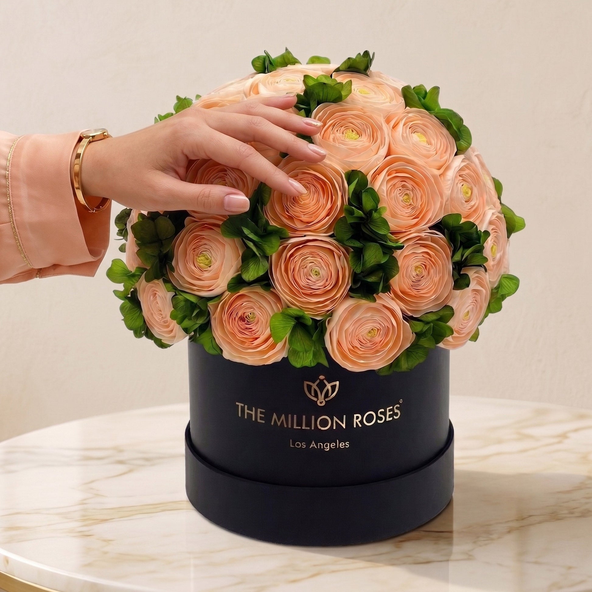 Peach Persian buttercups with green hydrangeas in a classic black box by The Million Roses on Tampa Home & Garden Store