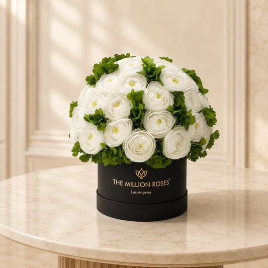 White Persian buttercups with green hydrangeas in a black The Million Roses hat box on Tampa Home & Garden Store