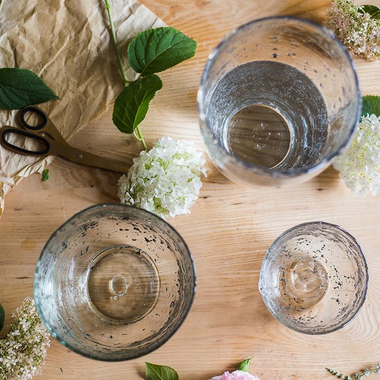 Clear art glass vases by RusticReach in three sizes on a wooden table with greenery on Tampa Home & Garden Store