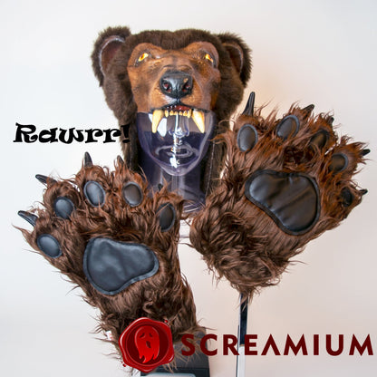 SCREAMIUM Cocaine Bear mask with brown fur head, yellow eyes, sharp fangs and paw gloves on Tampa Home & Garden Store