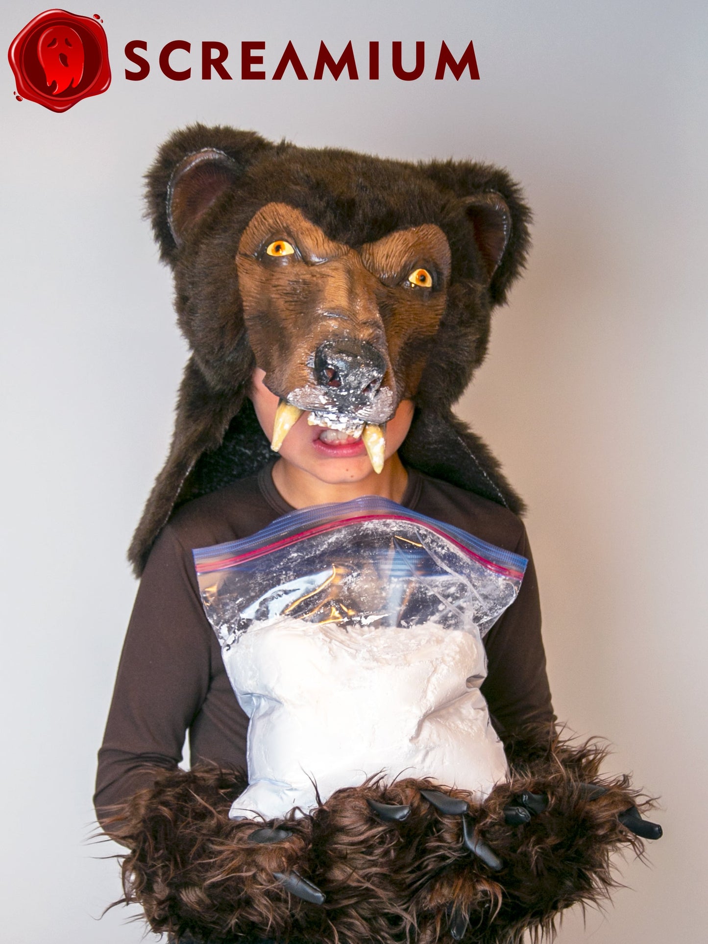 Cocaine Bear costume mask in brown fur with helmet head and fangs; SCREAMIUM logo visible on Tampa Home & Garden Store