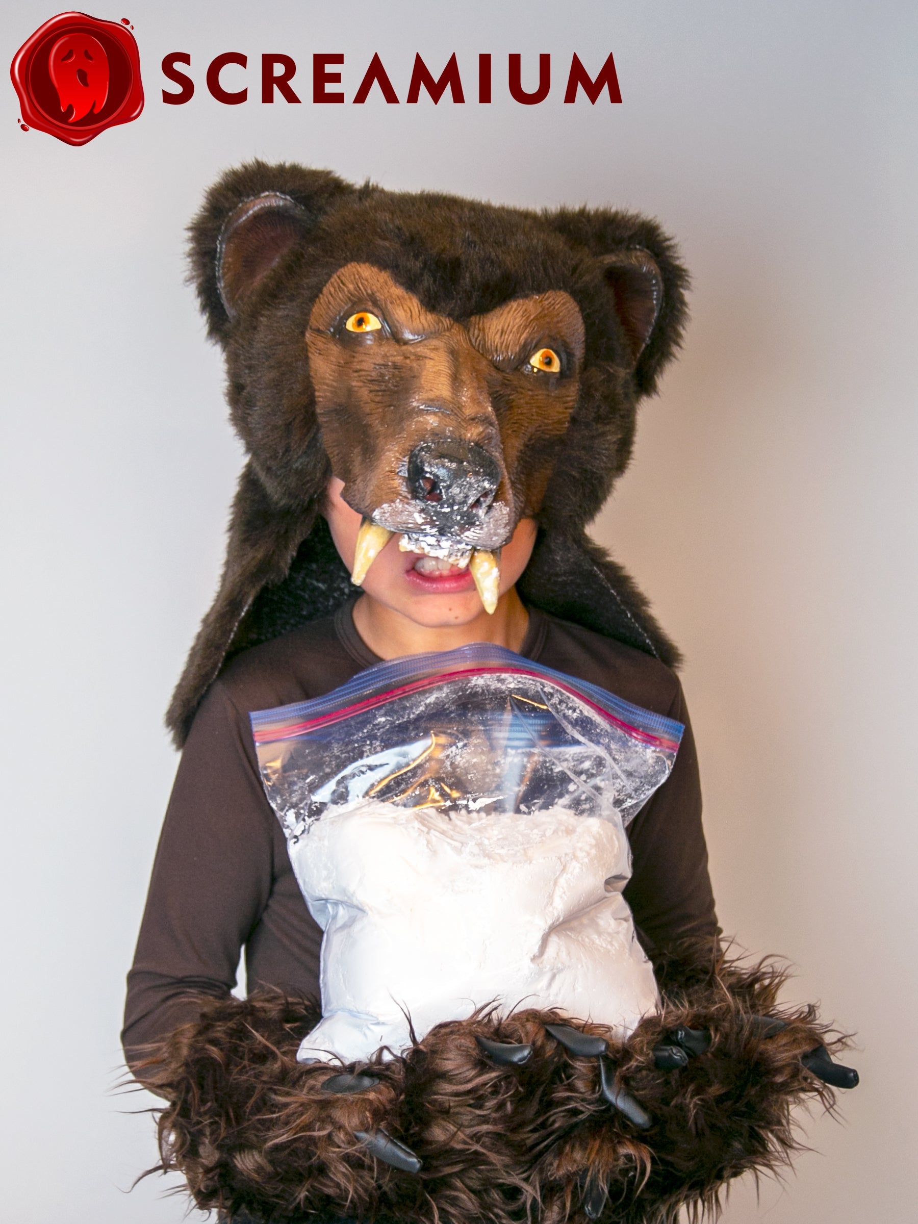 Cocaine Bear costume mask in brown fur with helmet head and fangs; SCREAMIUM logo visible on Tampa Home & Garden Store