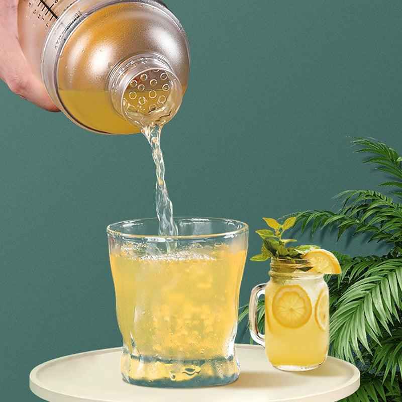 Shaketea 2-piece plastic cocktail shaker and glass pour golden drink into tray with lemon garnish on Tampa Home & Garden Store