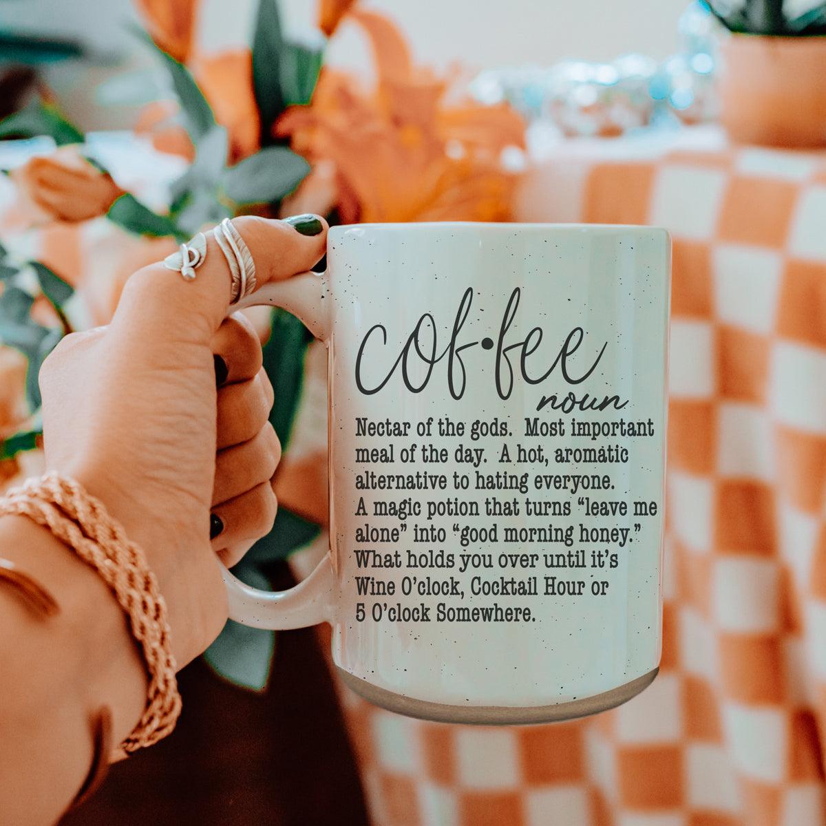 Coffee Def 16oz mug Gia Roma with speckled pale blue glaze held by a hand against backdrop on Tampa Home & Garden Store