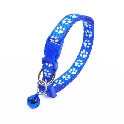 Blue paw-print nylon adjustable dog collar with plastic buckle, metal D-ring, and small blue bell on Tampa Home & Garden Store