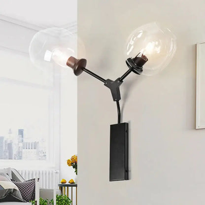 Black gold clear-glass wall sconce with dual bulbs and black metal arms on a backplate on Tampa Home & Garden Store