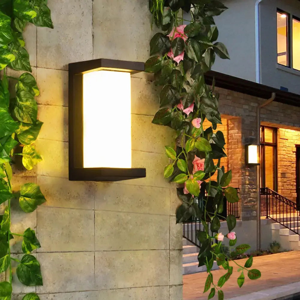Decorbites Black LED Flush Wall Lamp, black metal wall fixture with warm glow on stone wall on Tampa Home & Garden Store