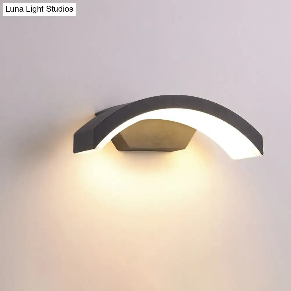 Black LED flush wall lamp with curved arc design and warm downward glow on Tampa Home & Garden Store