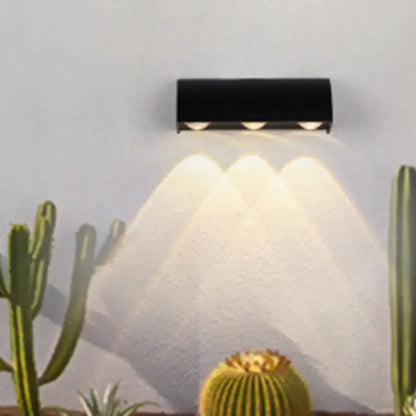 Decorbites black metal wall sconce with three downward lights on wall on Tampa Home & Garden Store