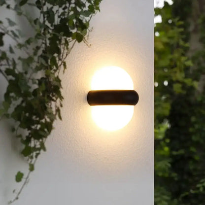 Decorbites black outdoor wall light: semi-sphere with a horizontal bar, warm glow on white wall on Tampa Home & Garden Store