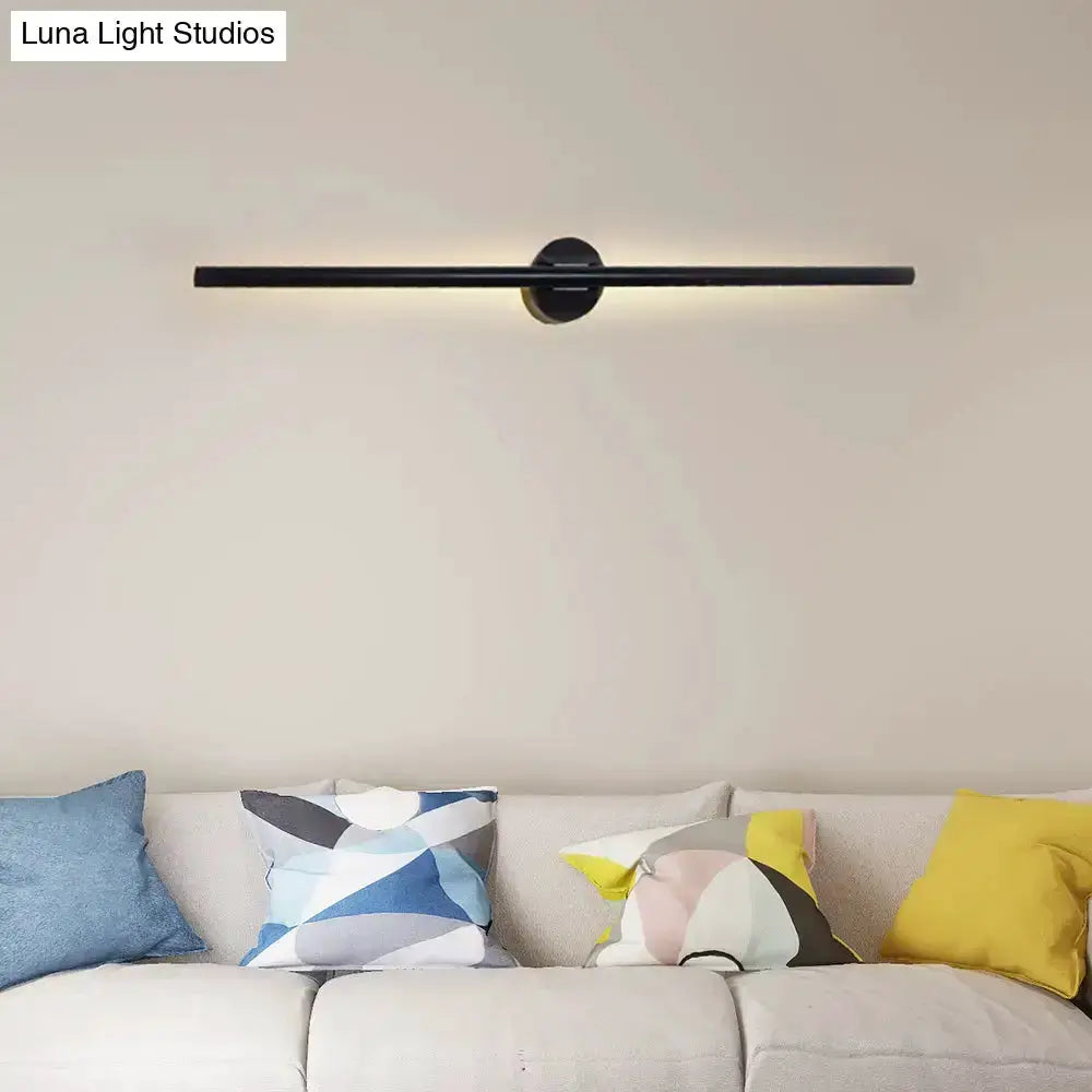 Contemporary black slim wall light fixture with round mount over a beige sofa on Tampa Home & Garden Store